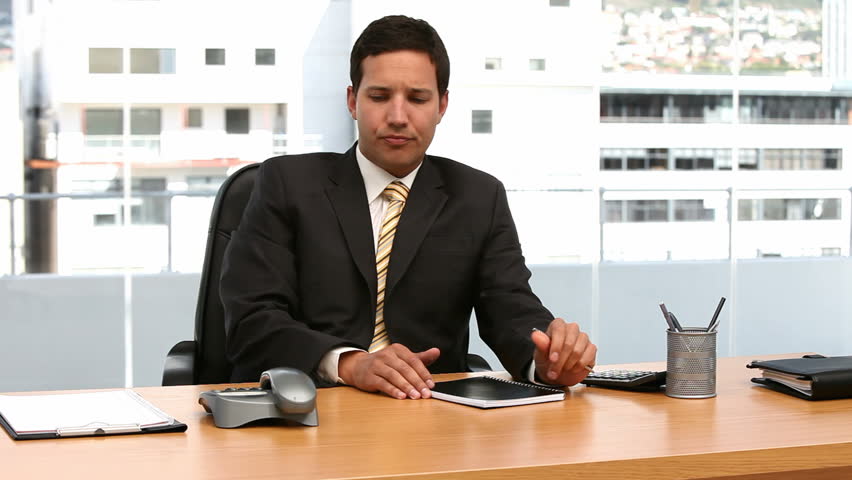 Cheerful businessman on the phone in his office