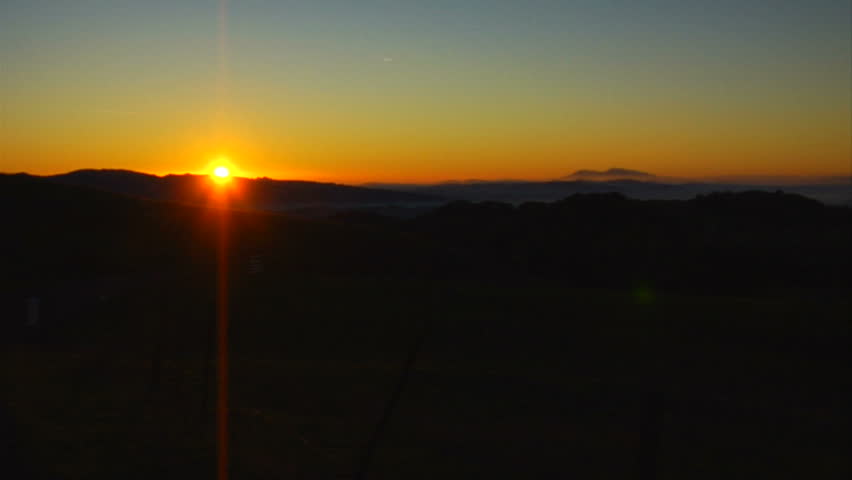 This is a wide locked off shot of a golden Napa Valley sunrise. Timelapse shows the sun rising over the distant rolling hills