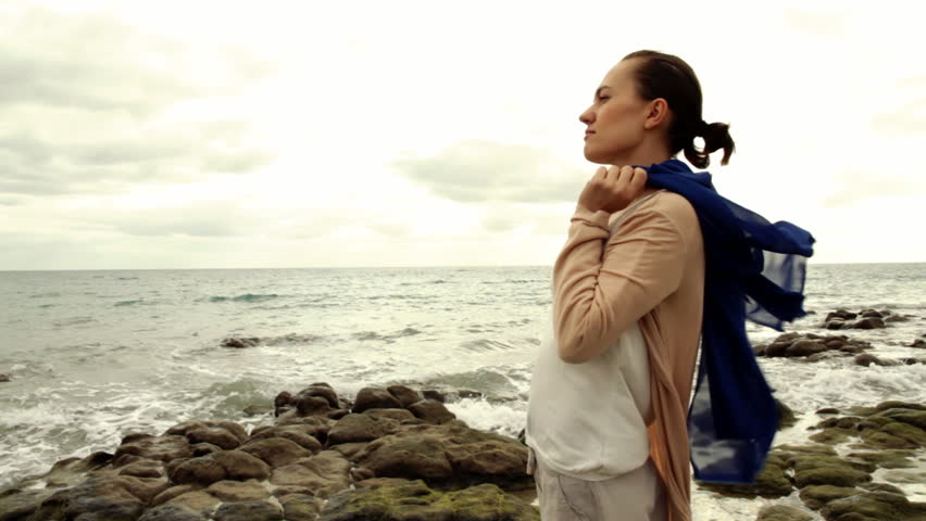 Young woman thoughtfully looking out to sea
