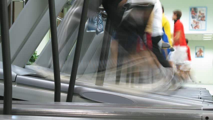 People run on treadmills at fitness club