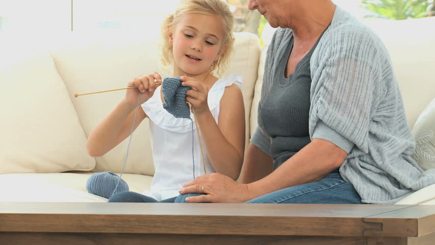 A Grandmother teaching to her grand daughter how to knit