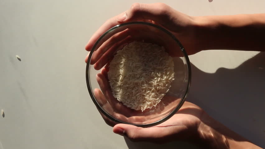 Rice poured into a bowl,given as charity or used to measure amount for recipe.