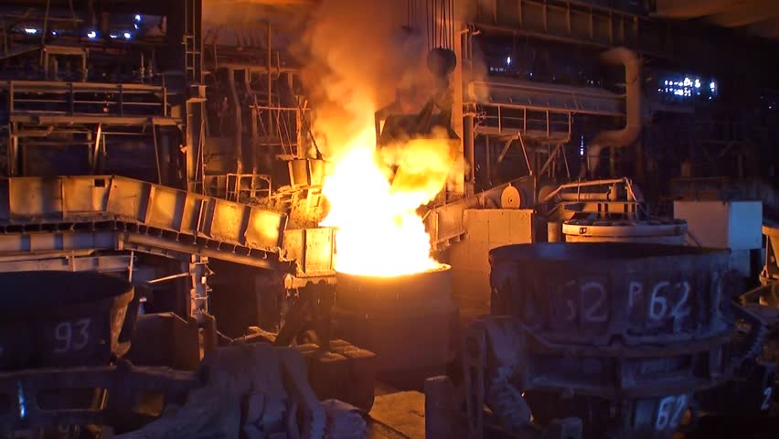 Loading additives into container with liquid metal in open hearth workshop of the metallurgical plant