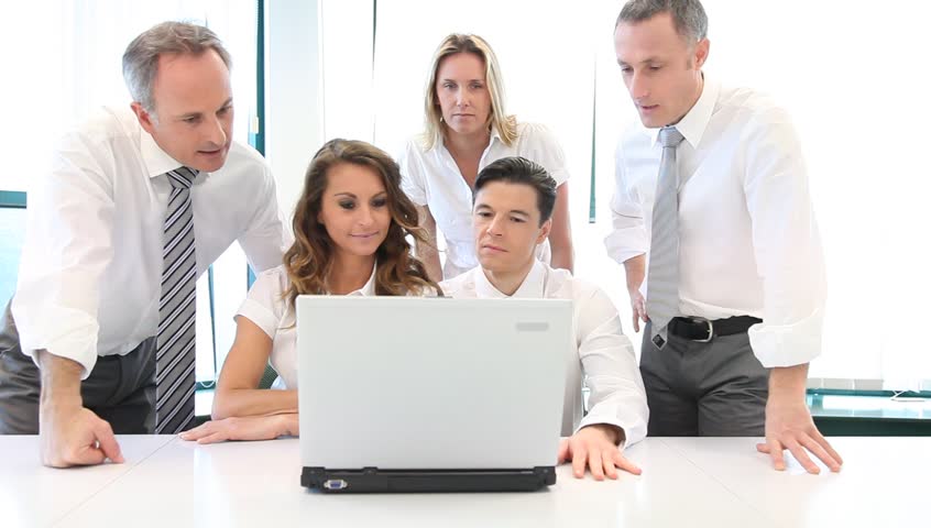 Group of office workers in front of laptop computer