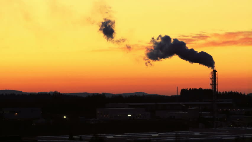 Sunrise silhouette of smoking factory