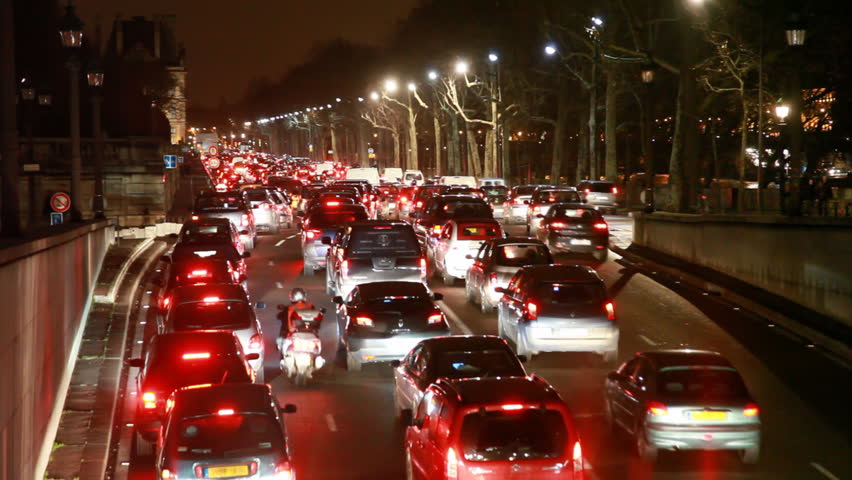 large concentration of vehicles traveling on highway in Paris near Louvre by night