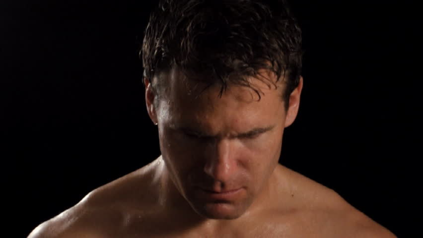 Intense sweaty male athlete looks into camera.