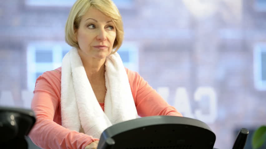 Mature woman exercising at health club; HD Photo JPEG