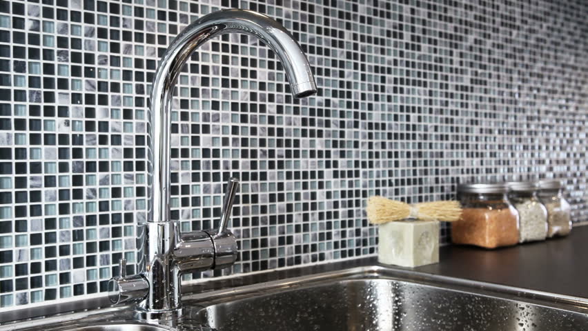 Washing hands in modern kitchen
