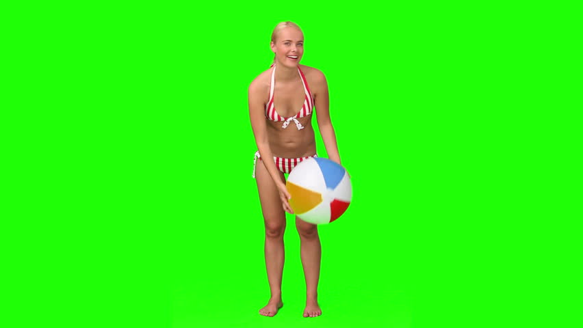 Chromakey footage of a blond woman in swimsuit playing with a ball