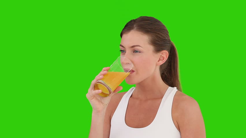 Chromakey footage of a cute brown-haired woman drinking orange juice