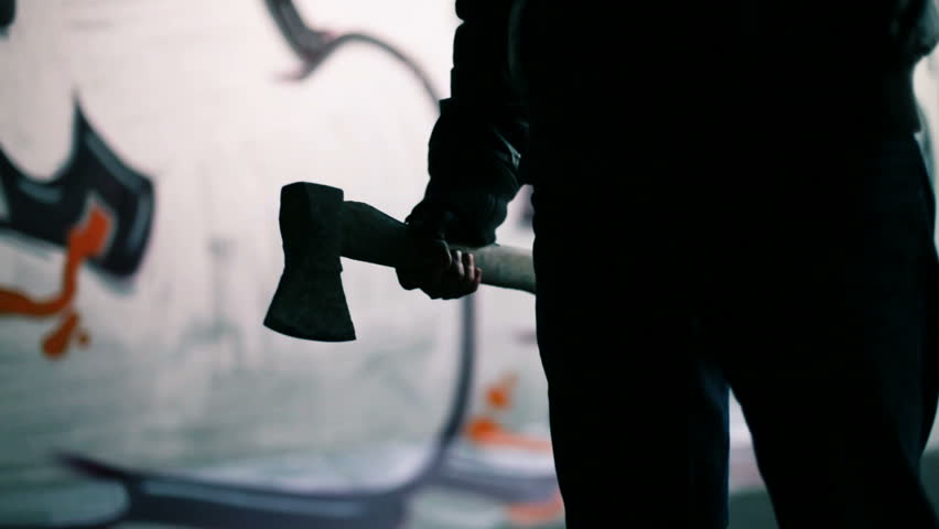 Concept of terrible man with axe on street 