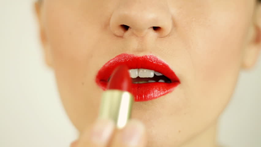Woman applying red lipstick, close up 