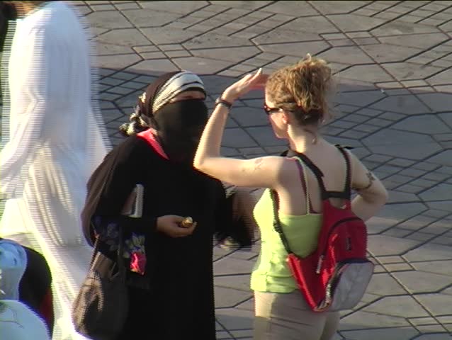 Western tourist talking with local woman in Marrakesh, Morocco.