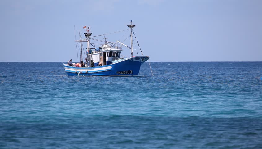 Fishing boat fishes at the coast