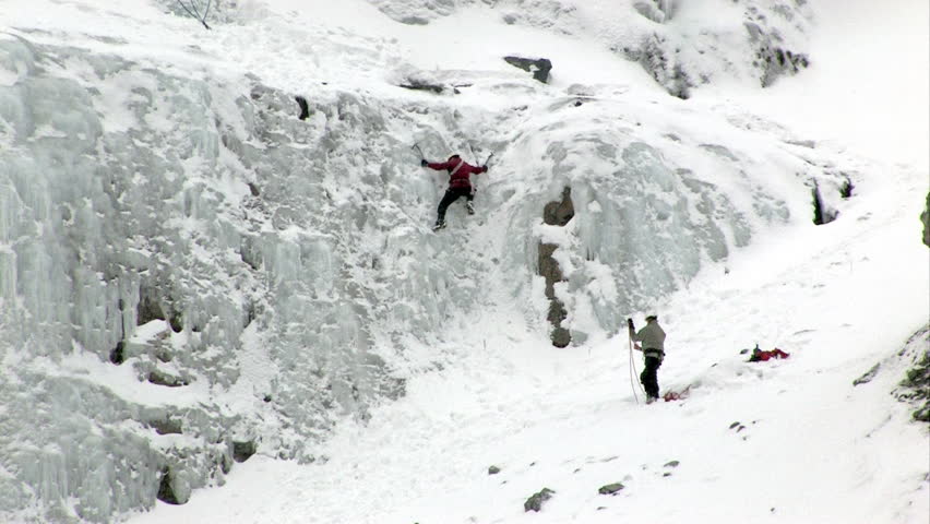 Video of ice climbers on small step climbing ice flow at Bridal Vale Falls in central Utah. Steep rock ledges with frozen waterfall. Athletic sport in cold weather. Wasatch Mountain range 