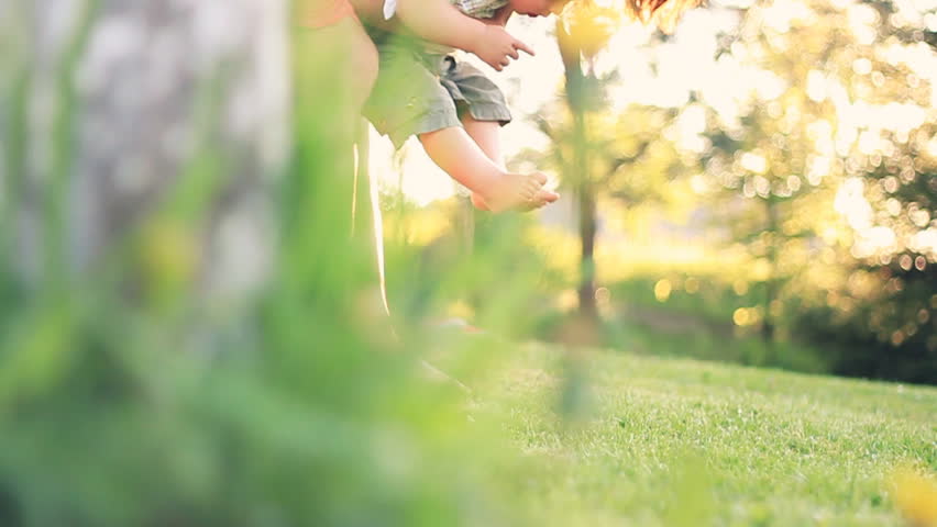 Baby first steps on grass, slow motion, dolly shot