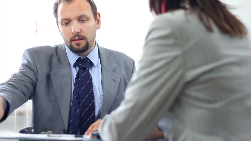Real estate agent signing contract and giving keys to female client