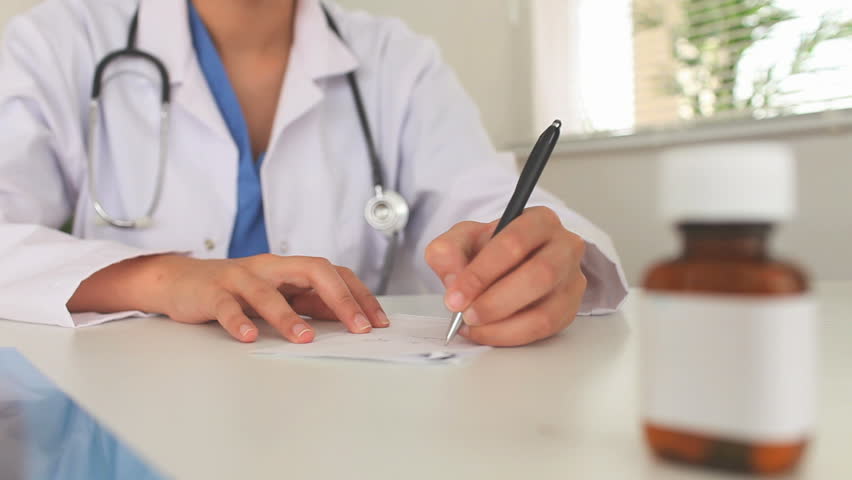 Young doctor writing a prescription in a hospital