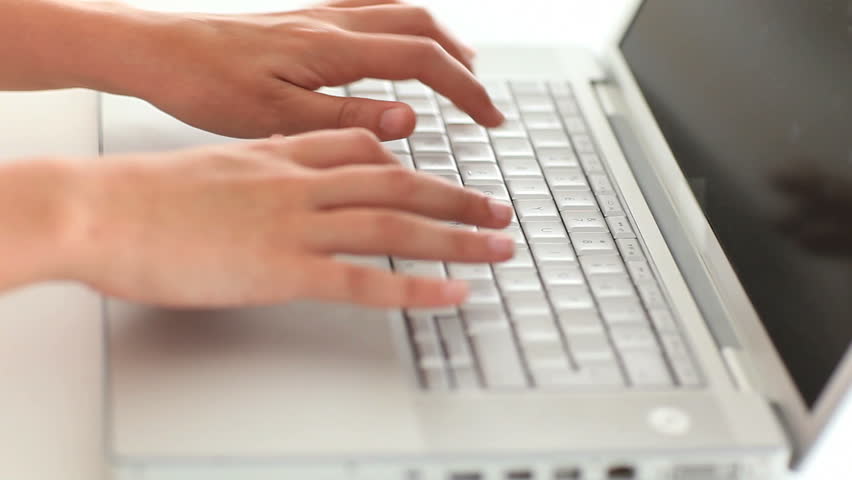 Femine hands typing on the keyboard of a laptop