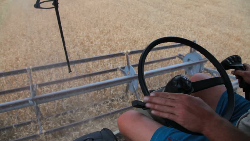 farmer driving combine harvester