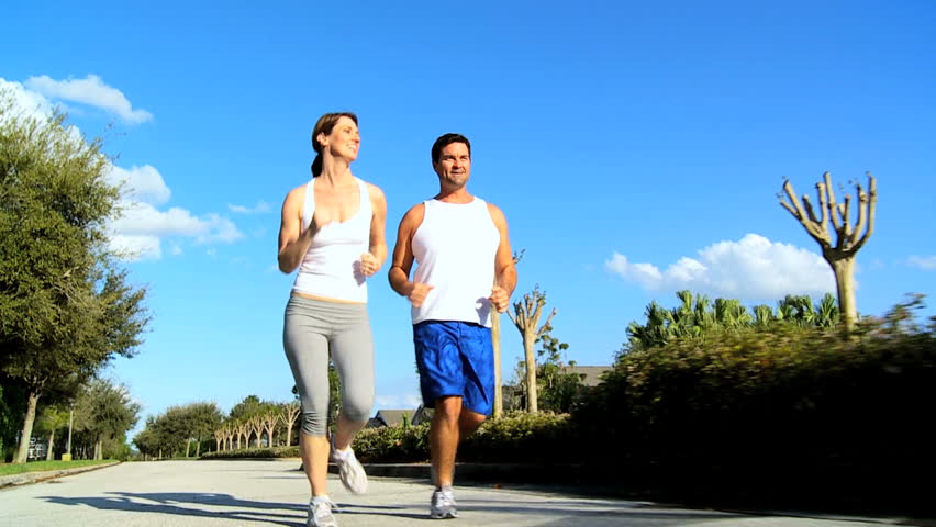 Young couple keeping fit jogging on suburban road