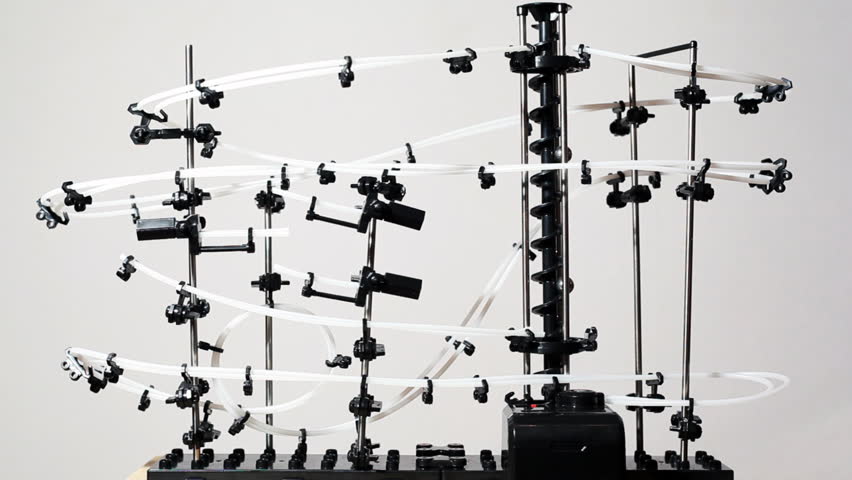 two balls roll through big interesting super construction with many levers, white background