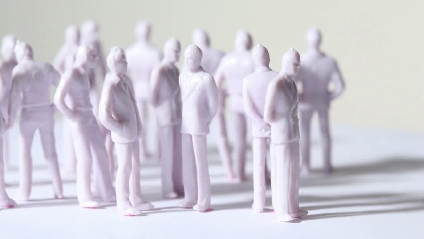 Group of little unpainted toy humans stand and drop shadows, composition rotates, sideview