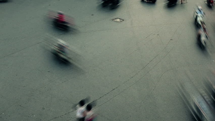 Busy junction with cars, bikes and pedestrians in timelapse