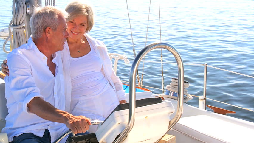 Healthy retired couple steering a course for the future aboard their luxury sailing boat filmed at 60FPS
