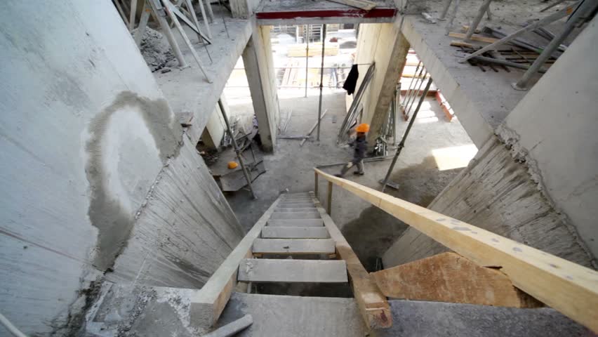 Builder walk up by wooden stairs on next floor, view from above