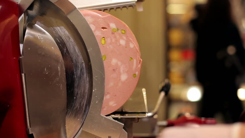 mechanical cutting sausage with pistachio in the shop