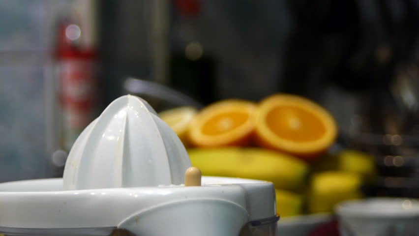 Squeezing fresh juice out of ripe tasty oranges and grapefruits