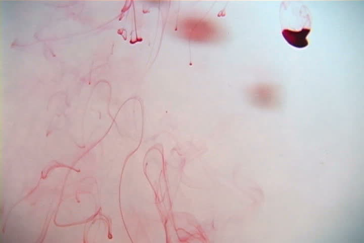 Blood droplets falling from above in liquified chamber.