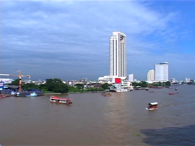 Pan of skyline from Bridge above Bangkok (Thailand)'s Chao Phraya river