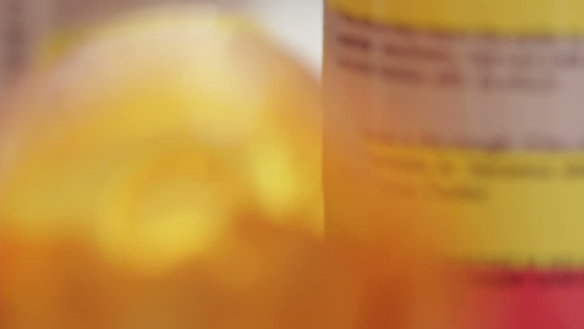 Dolly shot of prescription bottles and pills