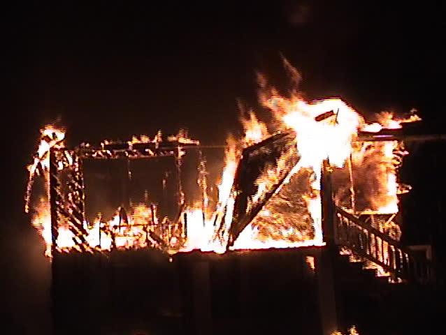 Structure fire at night with the porch roof collapsing.