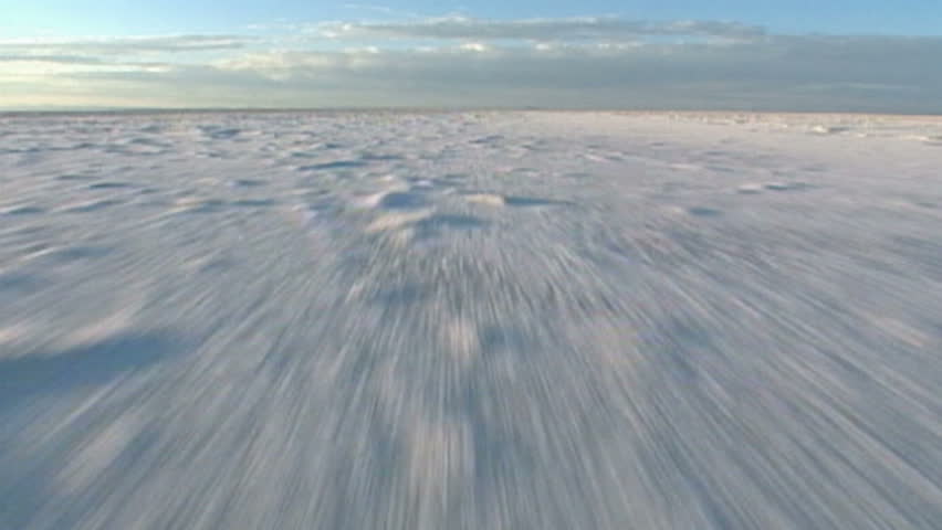 Camera flies low over eerie, dramatic moonscape salt flats.