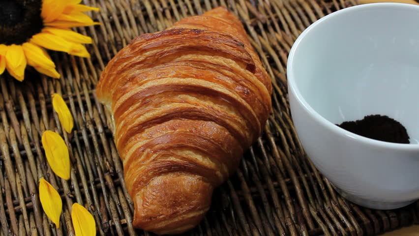 Hot water poured over instant coffee creates rich, steaming brew to wash down crispy croissant. 1080p