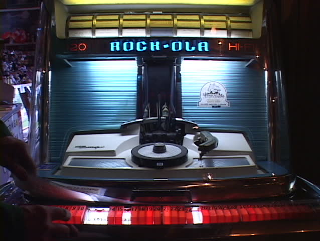 A 45 rpm record is played on an old fashioned jukebox.