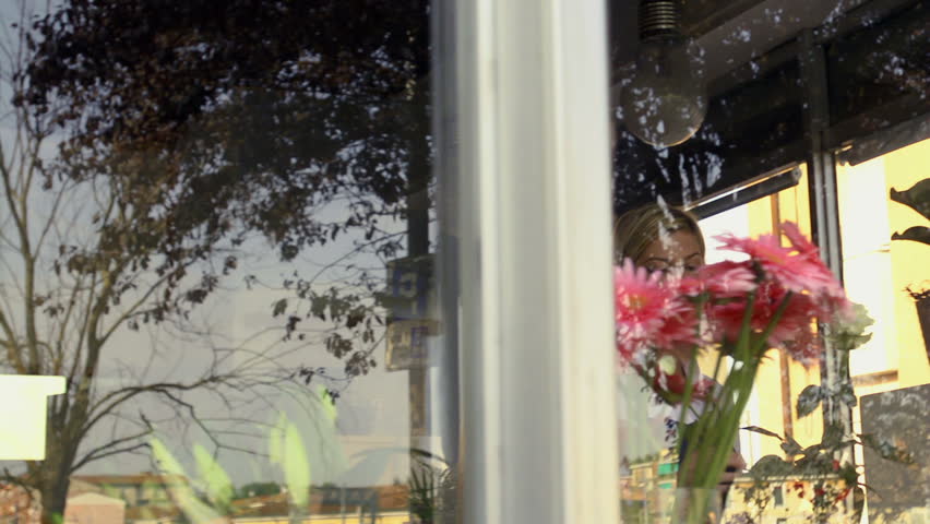 Businesswoman in her own flower shop, preparing bouquet and holding white roses. Dolly shot