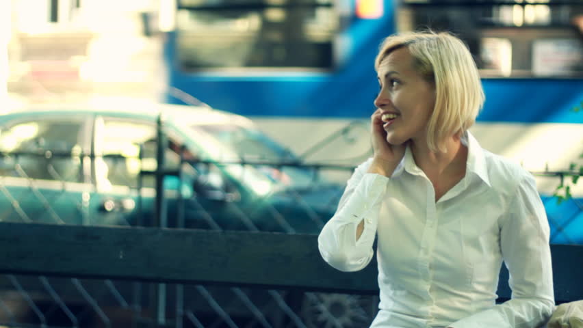 Businesswoman talking on cellphone by the city street, camera stabilizer shot