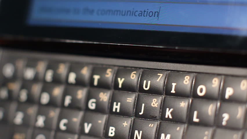 HD macro footage of a QWERTY keyboard smart phone with the message "...Communication age." being texted