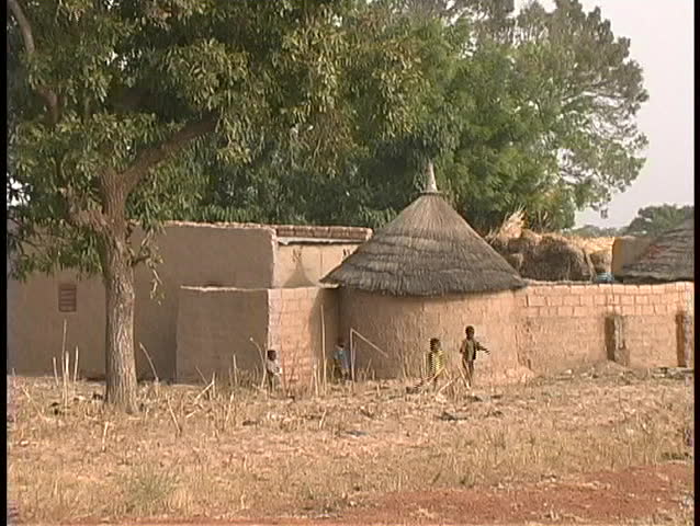 A medium shot of children playing outside the mud huts of Dogon Village in Mali, West Africa.