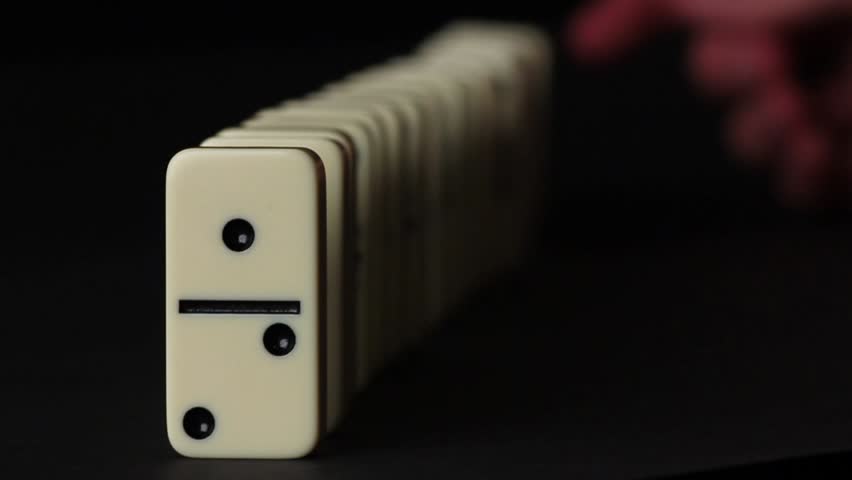 Domino stones falling, on a black background. Shot on a DSLR. Great depth of field.