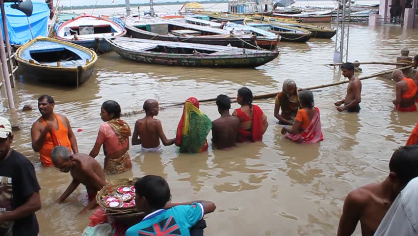 VARANASI, INDIA - AUGUST 11: Hindu pilgrims bathe in waters of holy river Ganges during monsoon floods, August 11, 2011 at Varanasi, Uttar Pradesh, India. Hinduism is a religious tradition of India, with 80.5% of the population identifying themselves as H