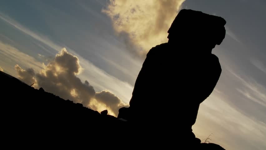 Clouds move mysteriously behind an Easter Island statue.