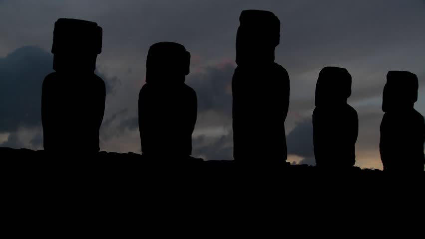A pan across Easter Island statues at dusk.