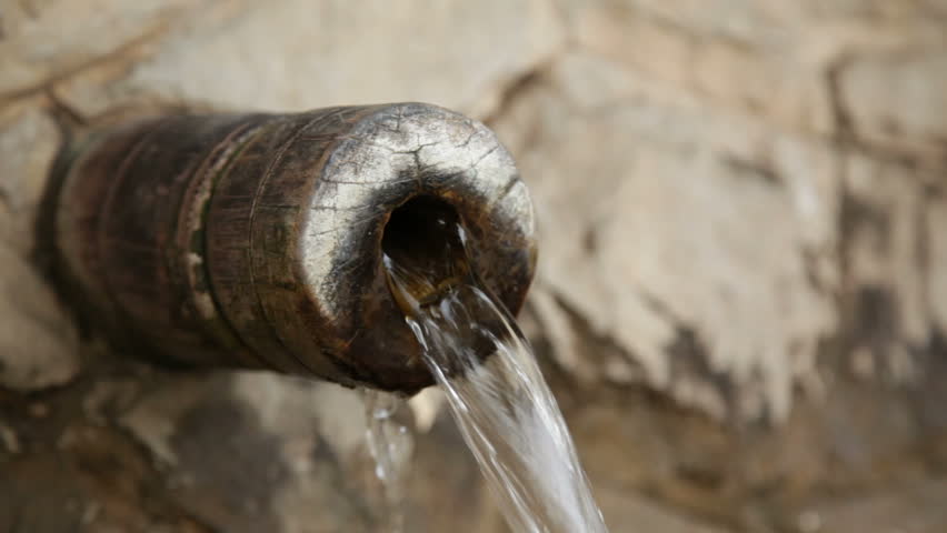 Water falling from an old wooden fountain. 