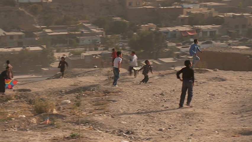 KABUL, AFGHANISTAN - CIRCA 2009: Boys play on the hillsides flying kites in modern circa 2009 in Kabul, Afghanistan. Afghanistan is an impoverished and least developed country, one of the world's poorest. 